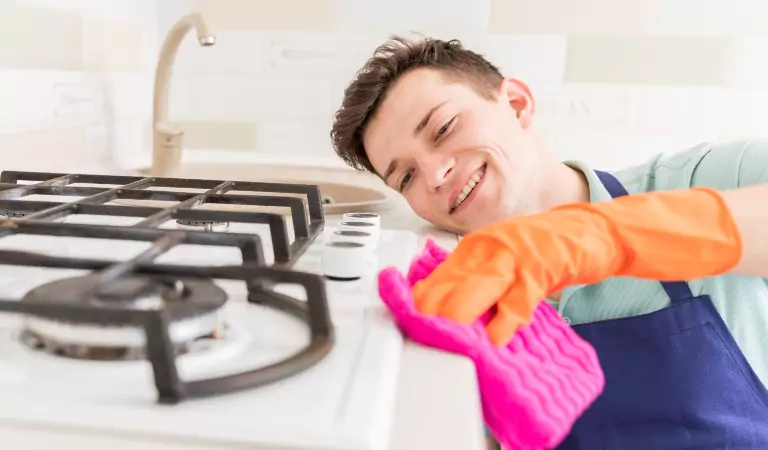 young man cleaning a gas stove
