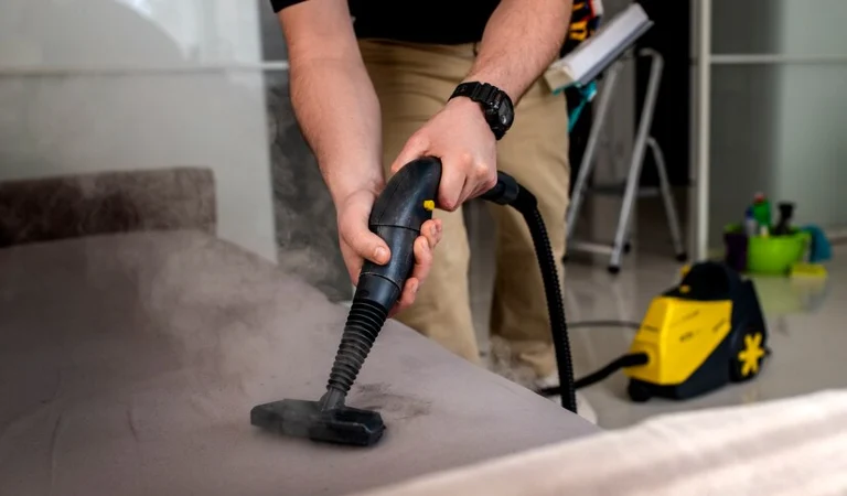 Woman cleaning upholstery using a steam cleaner
