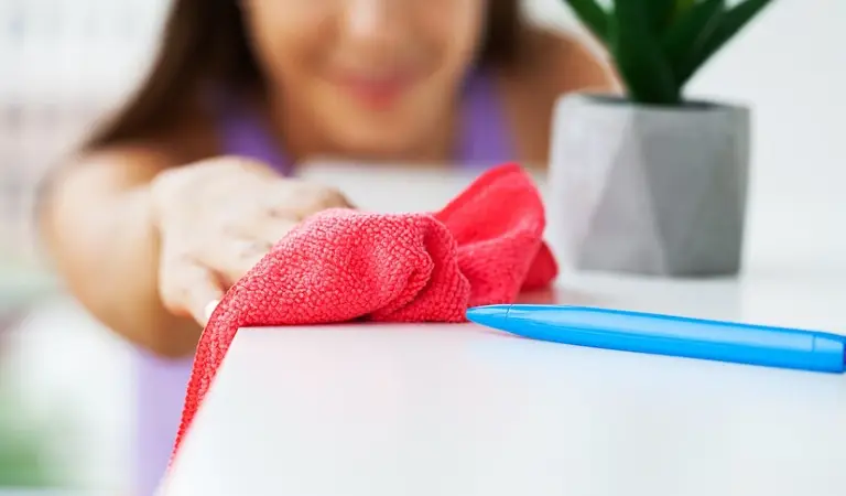 Woman cleaning a table with a red cloth