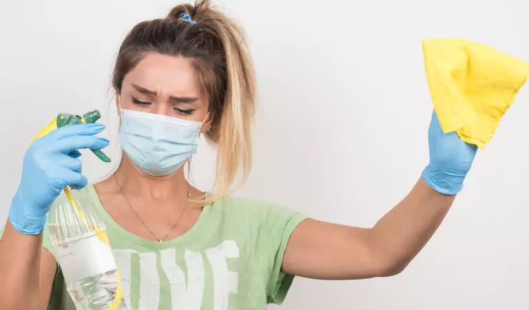 young woman with a mask ready to clean her house
