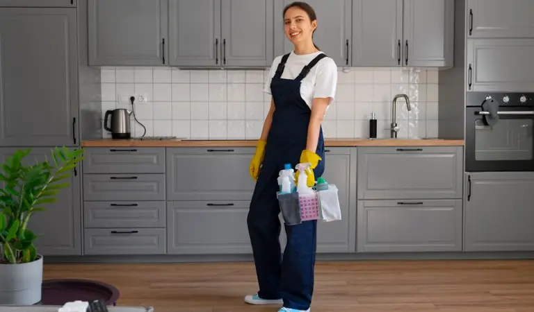 Professional cleaner in white black uniform holding a cleaning basket.