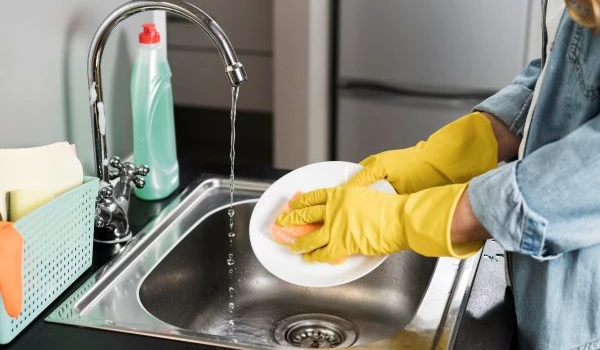 side view woman washing plate sink