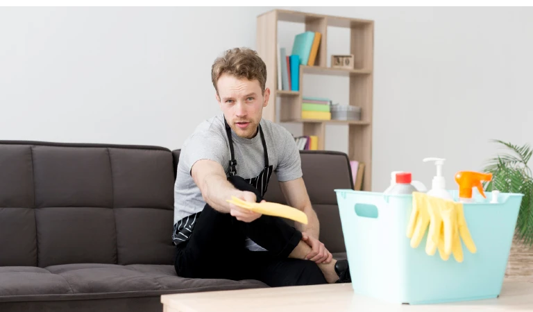 Low angle man on break from cleaning on couch