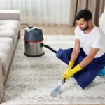 Man cleaning carpet in the living room using vacuum cleaner at home