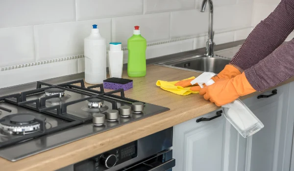 Wife in the kitchen wipe in yellow gloves, cleaning for care and protect yourself. Hygiene housework
