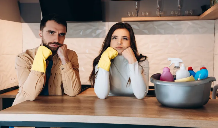 Wondering couple doing house cleaning in modern kitchen at home.Photo of young man and pretty woman washing with detergent and with wife.