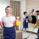 Young woman standing by sofa at home