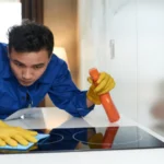 Worker cleaning stove surface