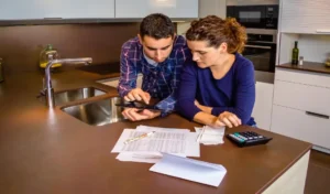 Couple looking at the tablet scren and some papers on a surface