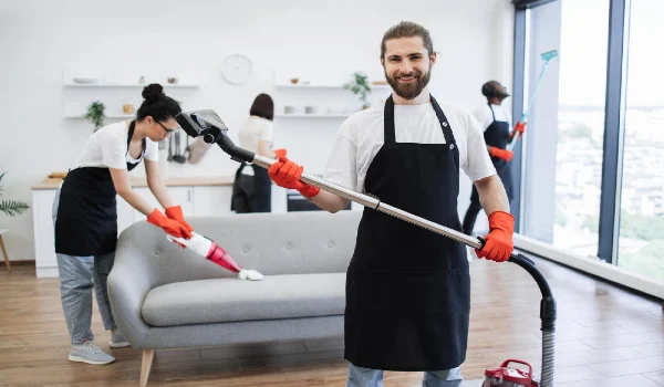 Portrait of bearded cleaner from cleaning service holding vacuum cleaner
