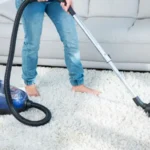 Woman using vacuum cleaner on carpet