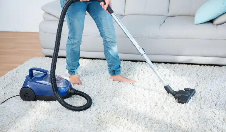 Woman using vacuum cleaner on carpet